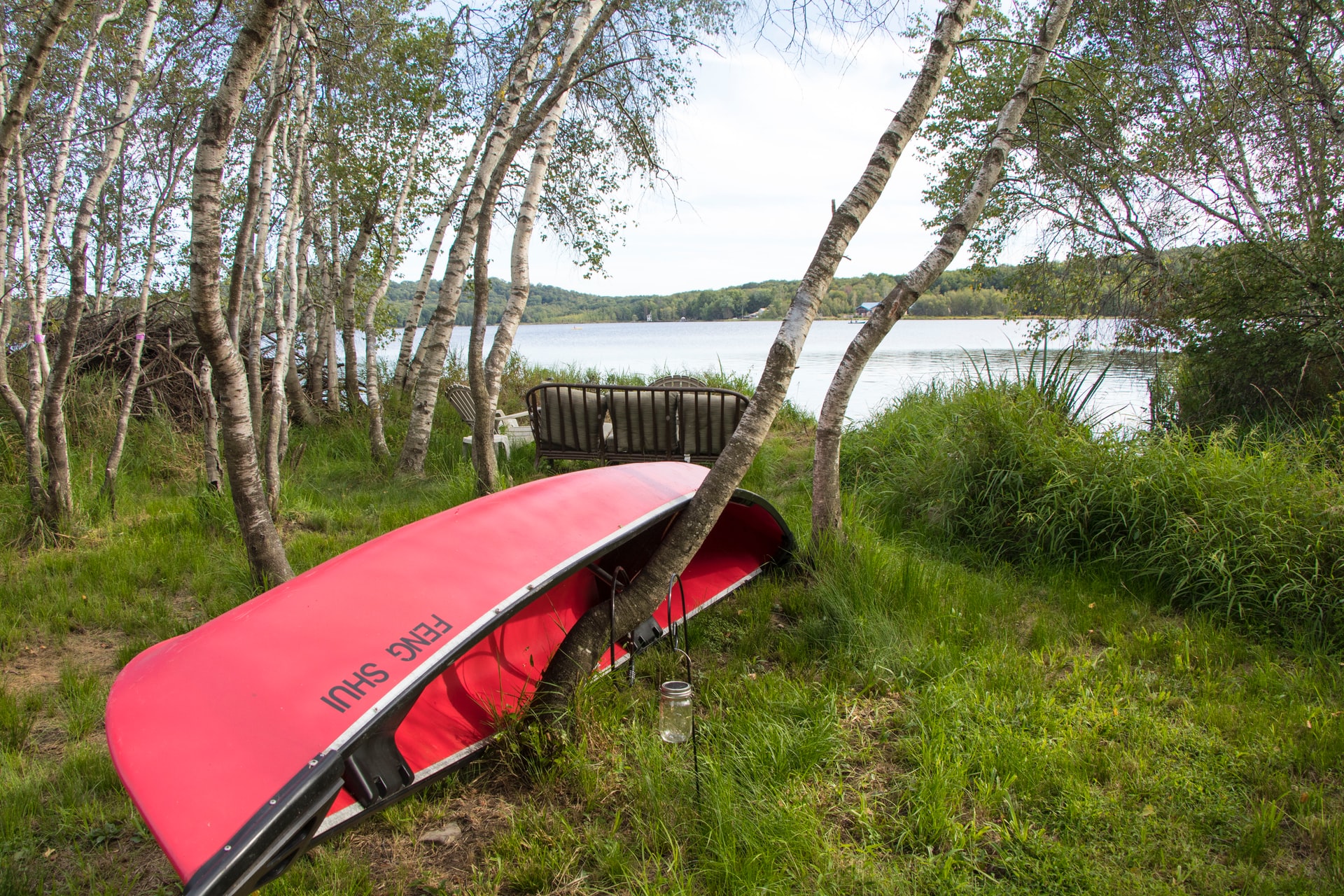 red canoe on shore of lake